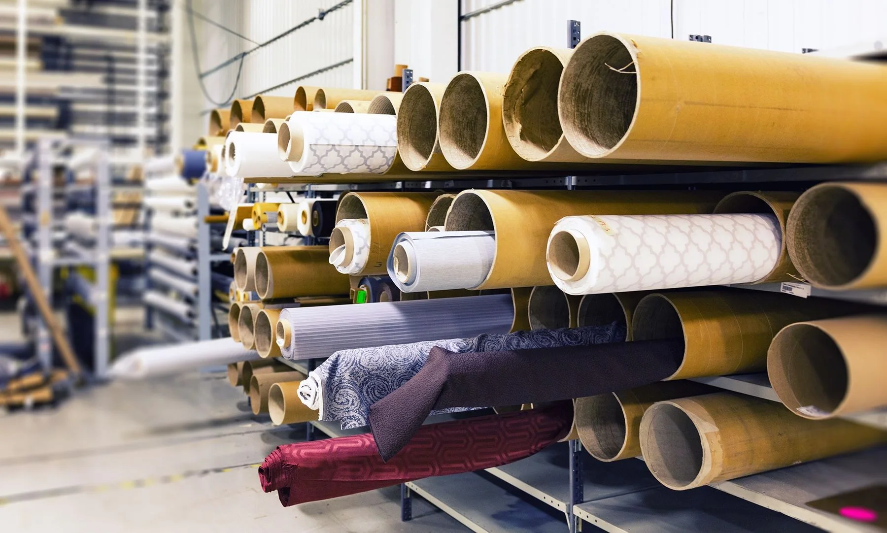 Shelved fabric rolls and cores organized in a textile workroom